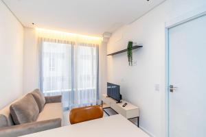 a living room with a couch and a television at Apto em prédio com Piscina, Região Nobre - TEM0205 in Curitiba