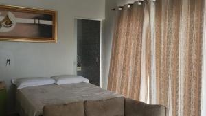 a bedroom with a bed and a window with curtains at Rancho Serra do Ouro in Alexânia +18 photos