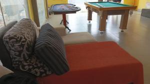 a living room with a couch and a pool table at Rancho Serra do Ouro in Alexânia