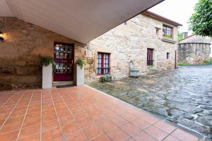 einen Eingang zu einem Steingebäude mit einer roten Tür in der Unterkunft Casa Dos Pazos in Brion