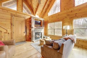 a living room with a fireplace in a log cabin at Elevated Cabin Bordering Smoky Mountain Nat'l Park in Bryson City