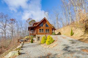 a log home on a hill with a driveway at Elevated Cabin Bordering Smoky Mountain Nat'l Park in Bryson City