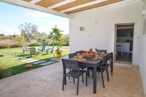 ein Esszimmer mit einem Tisch und Stühlen auf einer Terrasse in der Unterkunft Villa Flora in Latiano