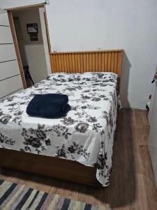 a bed in a bedroom with a blue blanket on it at Casa praia in Caraguatatuba