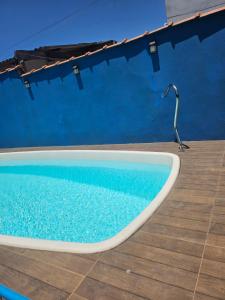 a swimming pool with a lamp next to a blue wall at Casa praia in Caraguatatuba