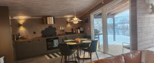 eine Küche mit Tisch und Stühlen in einem Zimmer in der Unterkunft Hytteparadis ved Neidenelva in Neiden
