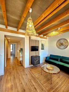 a living room with a green couch and a table at Apartamentos de la Huerta in Alicante