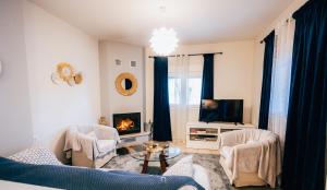 un salon avec un canapé et une télévision dans l'établissement Αγροικία Mυλόδεση, à Kalavrita