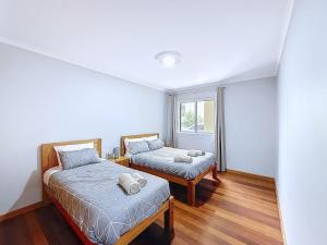 ein Schlafzimmer mit zwei Betten und einem Fenster in der Unterkunft Apartamento Bela Vista in Estreito da Calheta