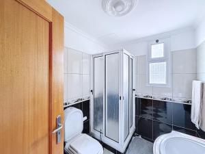 ein Badezimmer mit Toilette und Dusche in der Unterkunft Apartamento Bela Vista in Estreito da Calheta + 7 Fotos