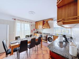 eine Küche mit einem Tisch und einigen Stühlen in der Unterkunft Apartamento Bela Vista in Estreito da Calheta