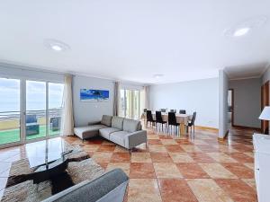 ein Wohnzimmer mit Sofa und Tisch in der Unterkunft Apartamento Bela Vista in Estreito da Calheta