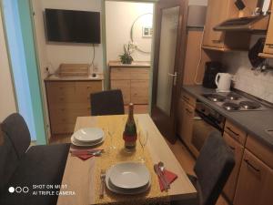Una cocina con una mesa con platos y una botella de vino. en Haus Habetseder, en Dorfgastein
