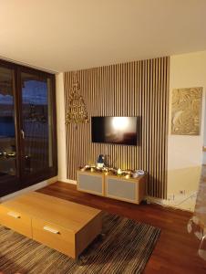 ein Wohnzimmer mit Fernseher und Couchtisch in der Unterkunft Refuge du Renard au Bord du Lac in Malbuisson