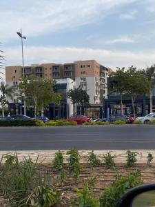 una calle con coches aparcados delante de un edificio en Butterfly, en Madinaty