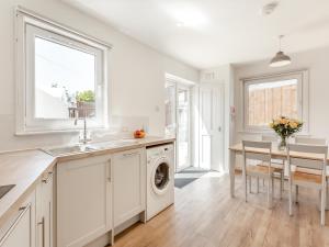 a kitchen with a sink and a washing machine at Dove Cottage in Inverness