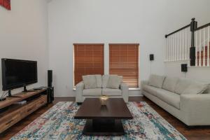 a living room with two couches and a tv at Fenced Backyard - Workspace - Near DFW Airport in Euless