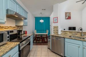 a kitchen with blue cabinets and a dining room at Fenced Backyard - Workspace - Near DFW Airport in Euless