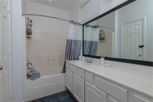 a bathroom with a tub and a sink and a mirror at Fenced Backyard - Workspace - Near DFW Airport in Euless +26 photos