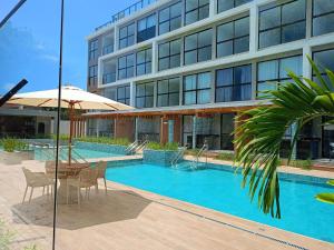 a swimming pool in front of a building at Flat has rooftop with barbecue and sea view in Tamandaré