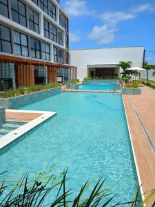 a large swimming pool next to a building at Flat has rooftop with barbecue and sea view in Tamandaré +5 photos