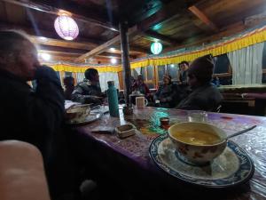 Un grupo de personas sentadas en una mesa con un tazón de sopa. en Paldor Peak Guest House, en Thāngjet 34 fotos más