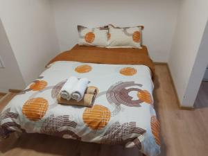 a bedroom with a bed with a comforter and towels at Spital 1 camera etaj 2 in Târgu-Mureş