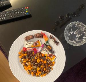 Un plato blanco cubierto con chocolates y aperitivos sobre una mesa en Butterfly, en Madinaty