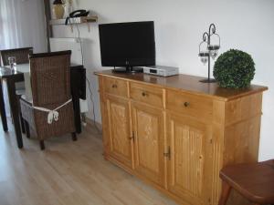 une commode en bois avec une télévision dessus dans l'établissement Gemütliche Ferienwohnung Mit Blick Auf Die Donau, à Obernzell 6 autres photos
