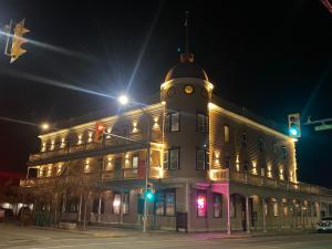 Un gran edificio con una torre de reloj por la noche. en coldwater hotel, en Merritt
