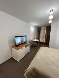 a hotel room with a bed and a flat screen tv at Montana Inn Slănic Moldova in Slănic-Moldova