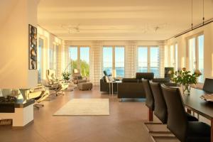 ein Wohnzimmer mit vielen Möbeln und Fenstern in der Unterkunft Appartement in Sellin mit Garten, Sauna und Terrasse und Meerblick in Ostseebad Sellin