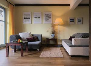 a living room with a couch and a chair and a table at Ferienhaus Im Idyllischsten Winkel Rügens in Neuenkirchen