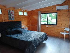 a bedroom with a bed in a wooden room at Depto Cabañero Lumai in Villa Ciudad Parque +1 photo