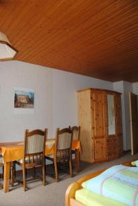 une chambre avec une table, des chaises et un lit dans l'établissement Ländliche Ferienwohnung In Beliebtem Gästehaus, à Goosefeld