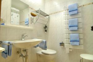 uma casa de banho com um lavatório, um WC e toalhas azuis em Curtins16 em Pontresina