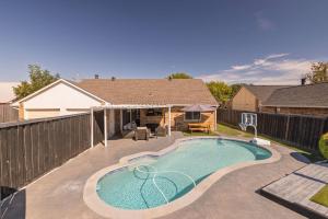 a swimming pool in the backyard of a house at Private Pool - Game Room - Backyard TV - Fenced Yard in Plano
