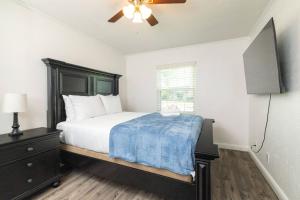 a bedroom with a bed and a flat screen tv at Private Pool - Game Room - Backyard TV - Fenced Yard in Plano