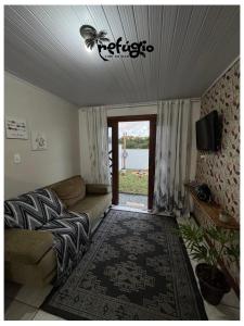 a living room with a couch and a tv at Refúgio Vibe do Mar in Barra Velha