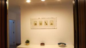 a white wall with three pictures on a wall at Sister's House by east ALgarve guest in Tavira