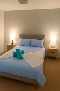 - une chambre avec un lit avec des draps bleus et deux lampes dans l'établissement Modern 1BR - Leeds City Centre - Balcony Views, à Central Station