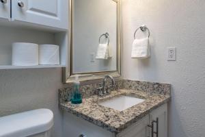 a bathroom with a sink and a mirror at Private Pool - Game Room - Backyard TV - Fenced Yard in Plano +24 photos
