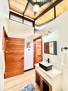 a bathroom with a sink and a wooden door at Finca Cacao in Pavones