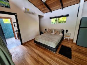a bedroom with a bed in a room with wood floors at Finca Cacao in Pavones +27 photos