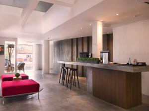 an office lobby with a bar with a red stool at T+ Hotel Butterworth in Butterworth