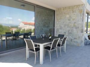 a dining table and chairs on a patio with a balcony at Villa Paradise in Vrbnik