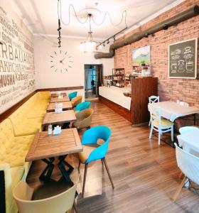 a restaurant with wooden tables and blue chairs at Twins MIRROR group HOTELS in Baku