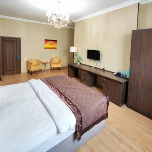 a bedroom with a bed and a desk with a television at Twins MIRROR group HOTELS in Baku