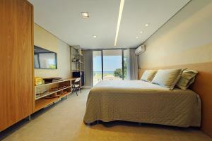 ein Schlafzimmer mit einem großen Bett und einem großen Fenster in der Unterkunft Casa Boutique Pontal da Ilha - 5 suítes - 14 pessoas in Itamaracá