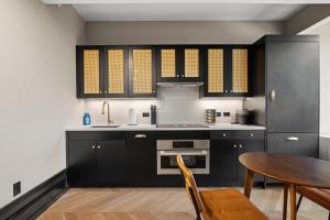 cocina con armarios negros y mesa de madera en Freeman 303 by Rove - 1BR Condo with Shared Amenities, en Nueva York 20 fotos más